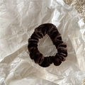 Primer plano de un coletero de terciopelo marrón oscuro que muestra su brillo y tejido - Café oscuro