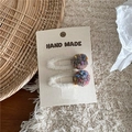 Detailed macro view of handmade colorful woven yarn balls on soft plush hair clips - Khaki Pom Pom Clips
