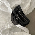 Detailed view of glossy black hair claw clip featuring elegant minimalist curved design - Black