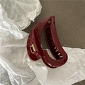 Detailed view of dark red hair claw clip with golden spring on grey stone background - Burgundy