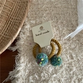 Close-up of handmade pom-pom hair tie with elastic spiral band on a display card - Green Pom Pom Hair Ties