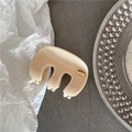 Détail de la pince à cheveux crème avec logo métallique doré gravé Hand Made dessus - Blanc Cassé
