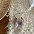 Detail of two pink elastic hair ties with colorful polka dot plush balls on a display card - White Pom Pom Hair Ties