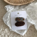 Detailweergave van ovale haarclips van tweed en pluche op een sieraden displaykaart - Donkere Koffie (Kleurrijk Ovaal Paar)