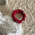 Détail d'un chouchou en maille rouge avec motifs de cœurs verts sur fond moelleux - Rouge