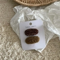 Detail van tweekleurige wollen haarklemmen in bruin en mosterdgeel op de kaart - Lichte Koffie (Kleurrijk Ovaal Paar)