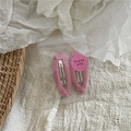 Close-up of pink fluffy fabric hair clips with silver metal duckbill base in gift packaging - Pink