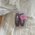Close-up of two fuzzy dark purple teardrop hair clips in packaging with a pink thank you sticker - Purple