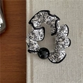 Detalle de coletero con estampado floral blanco y negro y una cuenta negra brillante - Floral Negro con Cuenta Negra y Borde Blanco