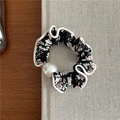 Vista detallada de coletero floral con perla y borde ondulado en tela negra suave - Tela Negra Floral Blanco con Cuenta Blanca