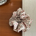 Detail eines geblümten Haargummis mit Spitze auf rustikalem Holzhintergrund - Einfacher Stil / Cremeweiß Blume