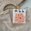 Detail of pink high-elastic hair bands in independent branded packaging on soft fabric - Light Orange