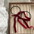 Detail of red velvet bow hair ties set with long ribbons on a jewelry display tray - Burgundy
