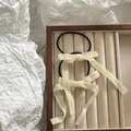 Detail of cream long ribbon bow hair ties set on a premium jewelry display tray - Off-white