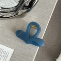 Close-up of a blue heart-shaped hair claw clip with glossy jelly texture and gold spring - Blue