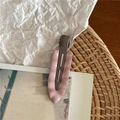 Dettaglio macro di un fermaglio per capelli in marmo rosa su uno sfondo naturale - Rosa