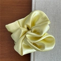 Close-up of premium satin scrunchie in cream yellow with elegant silk texture - Yellow