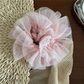 Détail d'un chouchou rose en tulle mesh multicouche sur un support en bois rustique - Rose