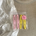 Close-up of pink and yellow matte teardrop hair clips in thank you packaging - H6.5 Yellow And Pink (Pea Shape)