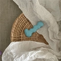 Detail of light blue wavy resin hair clip placed on a rustic woven basket rim - Blue