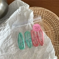 Détail de quatre barrettes goutte à motif écossais vert et rouge dans un sachet - Mélange Rouge Vert