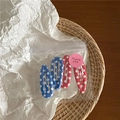 Close-up van schattige haarspeldjes met stippen in transparante verpakking met bedanksticker - Gemengd Rood Blauw Gestippeld