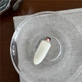 Close-up of a sleek white USB-C adapter on a textured glass plate with modern aesthetics - Off-white
