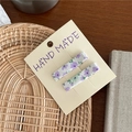 Nahaufnahme von zwei lila Haarspangen mit Blumenmuster auf einer Displaykarte - Lila Blumen Rechteck Stil / Lila