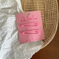 Detail view of two cream-colored pink drip oil waterdrop hair clips on card packaging - Rose Pink