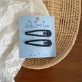 Detail of two dark blue teardrop hair clips on a light blue cardboard display card - Navy Blue