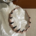 Dettaglio del cerchietto in raso marrone intrecciato con denti antiscivolo neri interni - Kaki