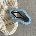 Close-up of wavy denim blue fabric hair clip on rustic beige linen background - Light Blue Cloud
