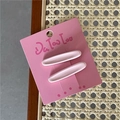 Detalle de las pinzas para el cabello ovaladas rosa claro en tarjeta con fondo de textura tejida - Rosa