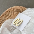 Detail van acetaat haarspelden met marmertextuur en gouden Barrette-belettering - Geel