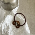 Dettaglio dell'elastico per capelli marrone con ciondolo a cuore in acetato e strass lucidi - Design a Motivo Ambra / Cuore Caffè Traslucido Chiaro