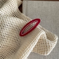 Detail of red hollow oval hair clip with micro-set rhinestones and Creation France engraving - Red