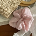 Vue détaillée du chouchou en tissu vichy rose et blanc sur un fond rustique chic - Rose