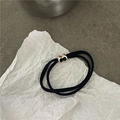 Dettaglio di elastico per capelli nero con fibbia geometrica in oro e smalto nero - Nero