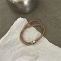 Detailansicht eines braunen Haargummis mit einem goldenen herzförmigen Metallschmuck - Schleife (H5.2 Khaki) / Khaki