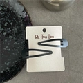 Dettaglio di un paio di fermagli per capelli neri opachi su una scheda di supporto - Nero Goccia (Coppia)