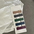 Primer plano de horquillas metálicas mate en tarjetas en cinco colores profundos - Onda Colorida Oscura