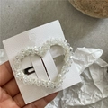 Macro detail of crystal beaded heart hair clip with silver metal spring mechanism - Clear