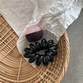Detailansicht eines schwarzen Spiralhaargummis mit einer rosa durchsichtigen Perle - Dunkler Mangostan-Stil