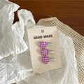 Detailed view of three purple gingham heart hair clips on a handmade card display - Purple Checkered Heart