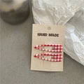 Dettaglio di fermagli per capelli a scacchi rossi e bianchi su carta decorativa - Grandi quadri rossi