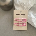 Dettaglio delle clip per capelli a scacchi rosa su confezione in carta fatta a mano - Quadri Rosa