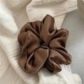 Close-up of a premium dark brown satin scrunchie on a textured fabric and stone background - Dark Coffee