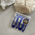 Detail view of four blue drip oil hair clips in handmade packaging on textured background - Royal Blue Waterdrop
