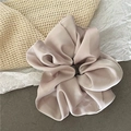 Detail eines großen champagnerfarbenen Satin-Scrunchies mit weicher Textur - Groß / Off-White