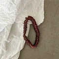 Close-up of a coffee-colored silk pleated scrunchie with a refined satin texture finish - Coffee